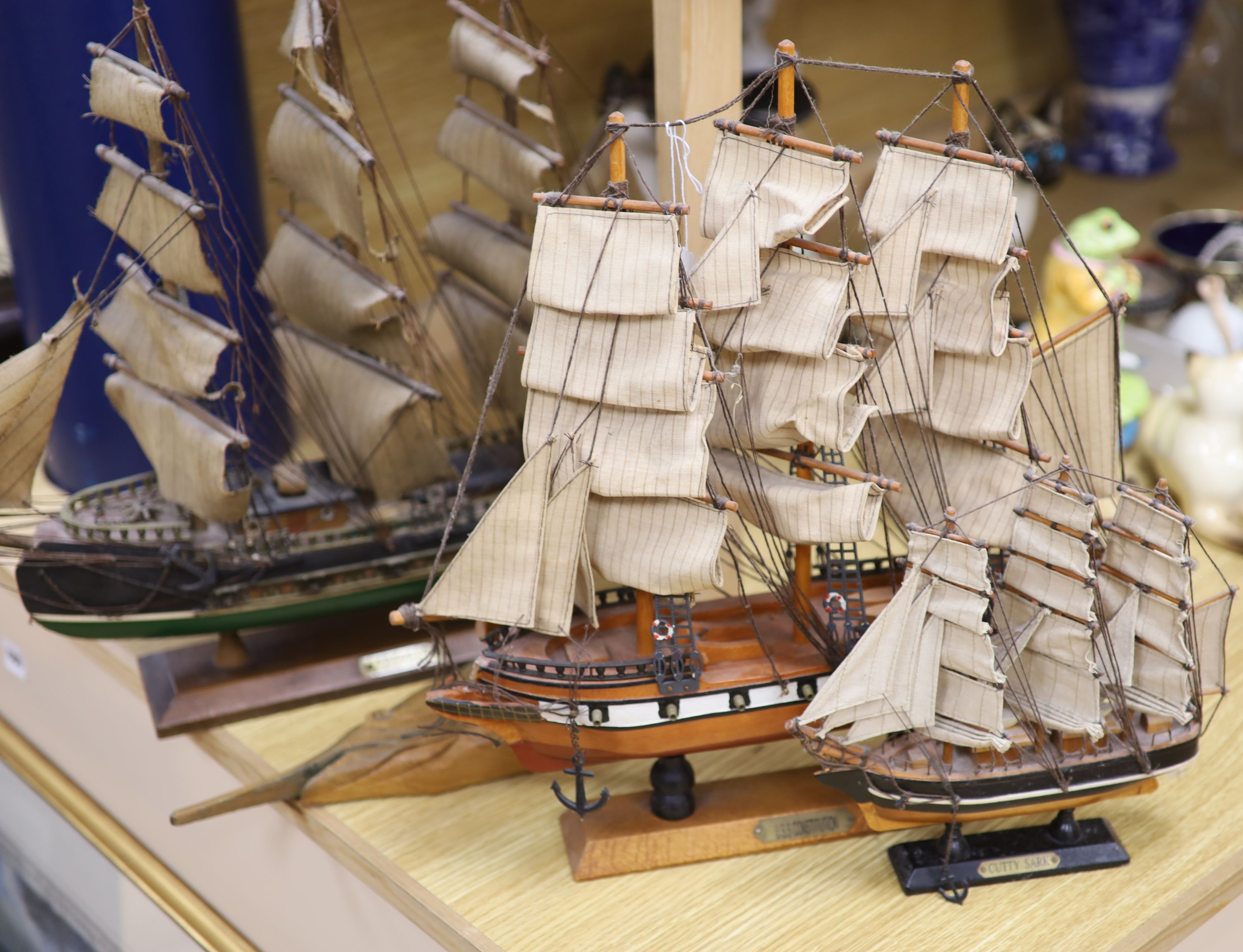 Three model ships: The Cutty Sark, The USS Constitution and Fragata, together with a carved wood Marlin